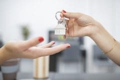 hands handing over keys for property purchase