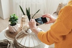 Woman diy blogger takes a photo on a mobile phone for diy blog in social media handmade jute rope lamp at home